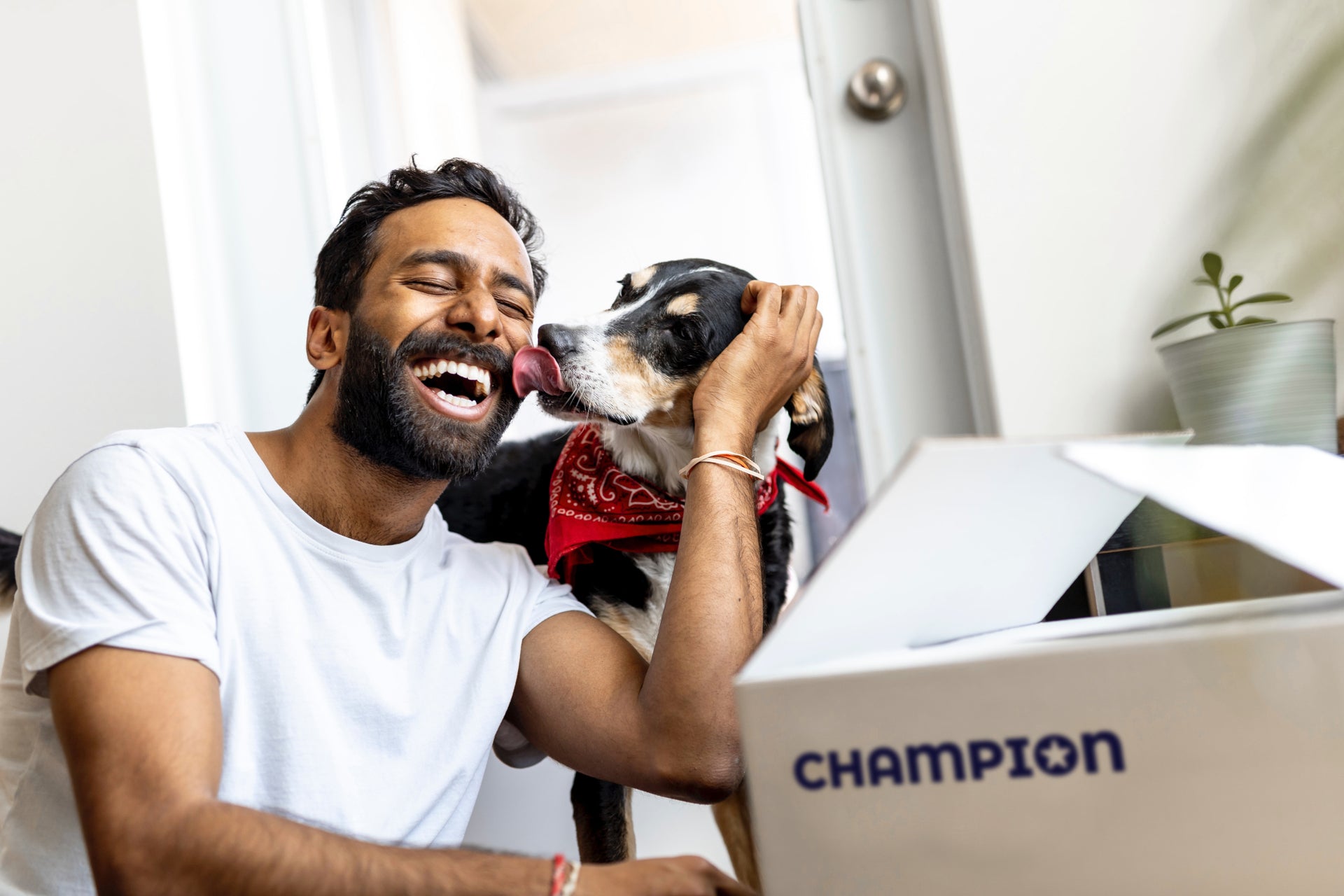 A happy man whit his dog who just received a package from the Champion store
