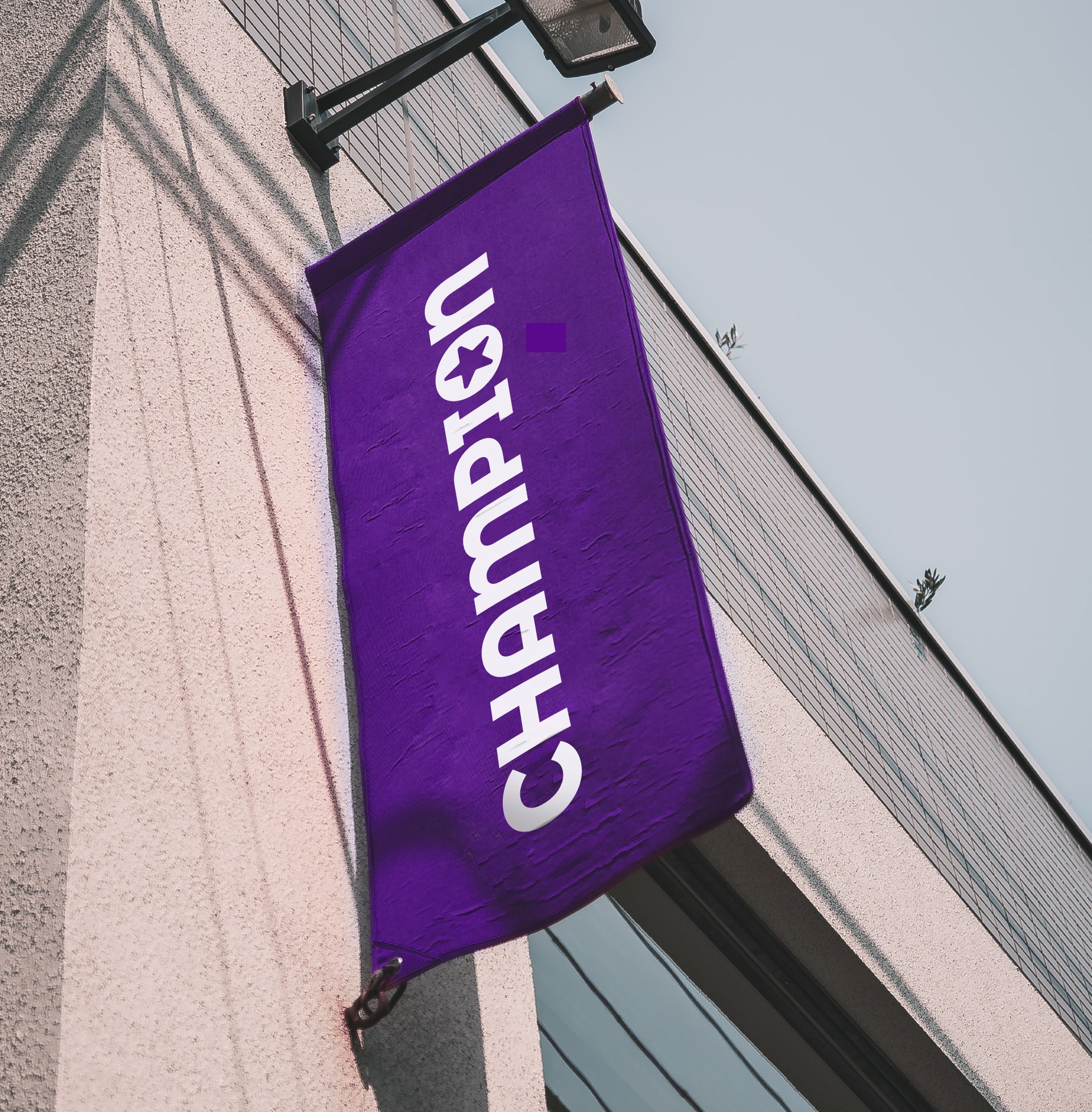 A purple banner on the exterior wall of a building with the Champion logo